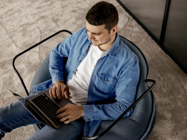 un hombre en una silla con una computadora portátil